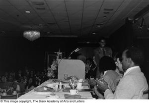 Photograph of a conference table and an unidentified man smiling