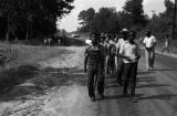 Edward Rudolph leading marchers down an unpaved road in Prattville, Alabama, during a demonstration sponsored by the Autauga County Improvement Association.