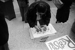 Demonstrator making a sign for a voter registration rally outside the Jefferson County courthouse in Birmingham, Alabama.