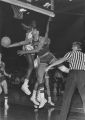 A Marquette basketball player attempts to prevent the opposing team from scoring, 1970