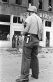 Police officer standing guard in the street across from the Silver Sands Restaurant and the Liberty Contracting Company, which were damaged during the 16th Street Baptist Church bombing.