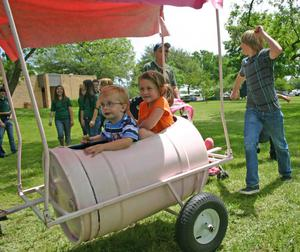 Children riding in barrel cart