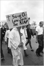 Klansmen and other marchers carrying signs in a parade during a Ku Klux Klan rally in Montgomery, Alabama.