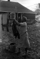 Mrs. Rosa Lee Turner hanging laundry on a clothesline in the dirt yard behind her house in Montgomery, Alabama.