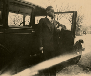 Theodore M. Sullivan posing next to car