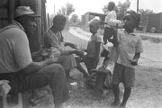 Man, woman, and children, eating and drinking outside a barn or shed near Mount Meigs in Montgomery County, Alabama.