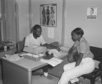 Students discussing paperwork with a professor or counselor at Tuskegee Institute in Tuskegee, Alabama.