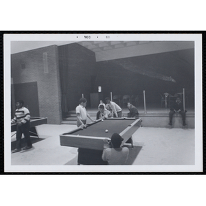 A Group of boys playing pool in the game room