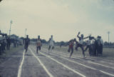 Runners crossing the finish line on the track during the annual high school track meet of the Alabama Interscholastic Athletic Association, probably held in Montgomery.