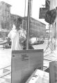 Woman walking past the window of a music store in Harlem.