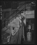 Thumbnail for Baltimore, Maryland. Building the SS Frederick Douglass. More than 6,000 Negro shipyard workers are employed at the Bethlehem-Fairfield shipyards where the Liberty ship is being rushed to completion. The noted orator and abolitionist worked as a ship caulker in the vicinity of this yard before he escaped from slavery. James Bibons, soldier in the battle of production, carrying insulated electric cables for engine room