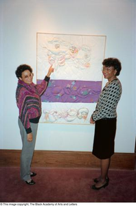 Photograph of two women looking at artwork