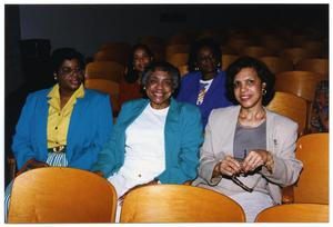 Women Seated in Auditorium Chairs