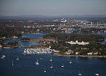 An October 2017 aerial view of New Castle, New Hampshire, with the historic seaport of Portsmouth, the largest city along the shortest coastline (18 miles) of any U.S. state, in the distance. The large white building with a red roof is the 1874 Wentworth-by-the-Sea Hotel, a historic grand resort hotel in New Castle. Now managed by Marriott, it is one of a handful of the state's surviving Gilded Age grand hotels, and the last located on the seacoast