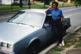 Mari Evans posing beside a car