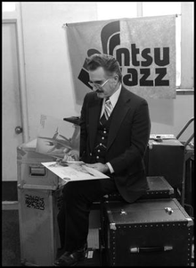 Leon Breeden sitting on trunk and holding albums