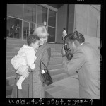 Sammy Davis Jr. taking photo of his wife May Britt and newly adopted son Jeff on steps of Los Angeles County Courthouse, Calif., 1965