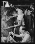 This Negro employee counter-sinks holes prior to riveting this wing panel. Negroes and whites work together at North American Aviation