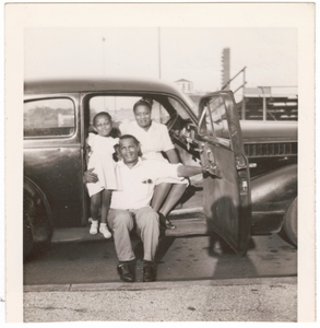 Photographic print of a family posed inside a car