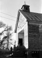 Thumbnail for People entering a wooden church building in rural Prattville, Alabama, probably for a meeting of the Autauga County Voters Association.