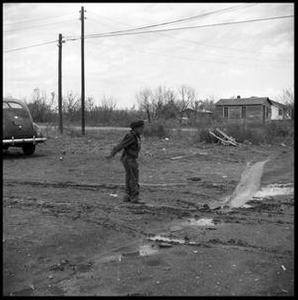 Boy in a Muddy Driveway