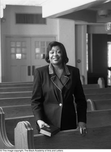 Photograph of Dorothy N. Cole Davis standing behind a church pew