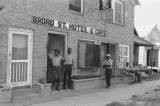 James "Son" Thomas and Joe Cooper in Leland, Mississippi. Bar, shoeshine parlor, promotional posters. (JTP 5-76-3)