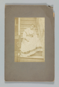 Albumen print of an unidentified woman sitting on stairs