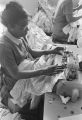 Woman sewing on a machine at Tuskegee Mills in Macon County, Alabama.