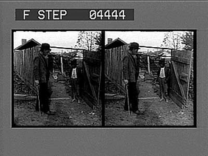 Boy and man in farmyard : stereoscopic photonegative.