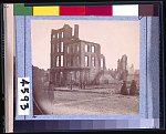 [View in the "Burnt District," Richmond, Va., showing two women dressed in black approaching shell of four-story building, gutted by fire]