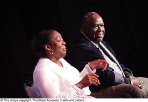 Performer and man sitting on stage