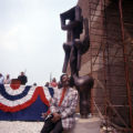 John W. Rhoden sitting in front of his sculpture