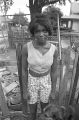 Young woman with a dog in the dirt yard in front of a house in Newtown, a neighborhood in Montgomery, Alabama.