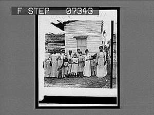 Adults and children pose before small building in Cuba. Active no. 111 : non-stereo interpositive.