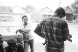 Young men seated on or standing around a pickup truck parked in front of Pugh's Superette on Foster Street in Newtown, a neighborhood in Montgomery, Alabama.