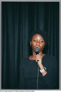 Photograph of a woman singing into a microphone