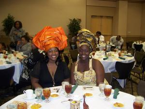 Two women in head wraps at banquet table