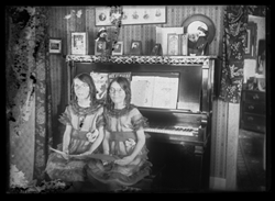 Two twin girls on a piano bench