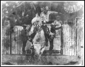 Cowboy participating in bull riding event at a rodeo