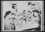 U.S. Negro troops on way to Liberia. Aboard a U.S. Army transport bound for Liberia, Africa officers of the Negro troops sit down for a meal. Left to right around the table; Lieutenant Abner R. Branch, oral surgeon; Captain Harsba F. Buoyer, war vetern and distinguished doctor; Captain W.D. Nabors; Warrant Officer Brice; Lieutenant Henderson, pathologist and tropical medicine expert; Edgar Rouezeau, correspondent of the Pittsburg Courier; Lieutenant Ned Manley, orthopedic surgeon and professor at Howard University , famous Negro institution, before entering the service; and Lieutenant Goldsberry, physician and holder of a master's degree in public health from Harvard University