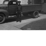 Fireman standing next to Oakland Fire Department truck parked in driveway of fire engine no. 22