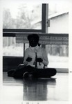 Girl sitting on the floor holding a carved item