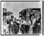 [The Eureka Brass Band in procession down a street in the French Quarter, New Orleans]