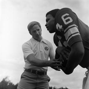 Football coach standing with a player