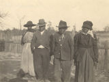 Four African Americans standing in front of a picket fence in Crawford, Alabama.