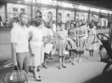 Group of African American travelers standing beside luggage and train tracks at Union Station in Montgomery, Alabama
