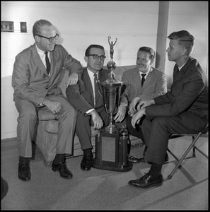 Leon Breeden and others sitting with trophy