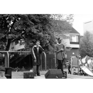 Two young men perform on an outdoor stage in Villa Victoria neighborhood.