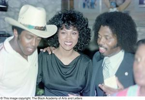 Thumbnail for Photograph of a woman smiling for the camera with Curtis King and Tony Dorsett